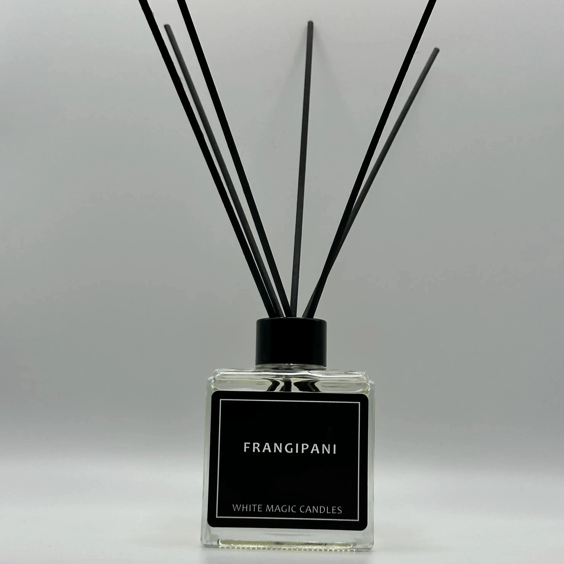 oil for reed reed diffuser bottle with a white label reading "FRANGIPANI" - WHITE MAGIC CANDLES."